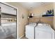 Convenient laundry room with washer, dryer, and shelving for storage, located off the garage at 2748 W Sunland Ave, Phoenix, AZ 85041