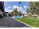 A covered patio leads to a backyard with a fenced pool, grass and mature landscaping at 302 W Thunderbird Rd, Phoenix, AZ 85023