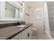 Bright bathroom featuring neutral colors, modern fixtures, vanity with dark countertop, and tiled shower at 302 W Thunderbird Rd, Phoenix, AZ 85023