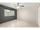 Bedroom featuring tile floor, ceiling fan, neutral paint, painted brick, and a view to the outside at 302 W Thunderbird Rd, Phoenix, AZ 85023