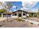 Inviting home exterior featuring a walkway leading to the front door, desert landscaping, and a two-car garage at 302 W Thunderbird Rd, Phoenix, AZ 85023