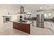 Bright kitchen with stainless steel appliances, an island cooktop, modern backsplash, and white cabinetry at 302 W Thunderbird Rd, Phoenix, AZ 85023