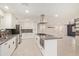 Bright kitchen featuring an island with a cooktop, stainless steel appliances, and white cabinetry at 302 W Thunderbird Rd, Phoenix, AZ 85023