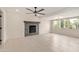 Open-concept living room with tiled floors, fireplace, modern ceiling fan, and bright natural light at 302 W Thunderbird Rd, Phoenix, AZ 85023