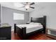 Bedroom features hardwood floors, ceiling fan, and natural light from a window at 323 N Hunt E Dr, Mesa, AZ 85203