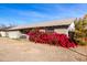 Single-story home with bougainvillea bush, neutral exterior, and blue sky above at 323 N Hunt E Dr, Mesa, AZ 85203