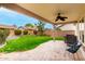 Covered patio with ceiling fan, grill, and seating overlooks the manicured lawn and backyard at 3632 E Comstock Dr, Gilbert, AZ 85296