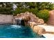 Rock waterfall and slide add a fun and natural element to this inviting swimming pool at 3632 E Comstock Dr, Gilbert, AZ 85296