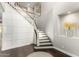 Elegant entryway with dark wood floors, staircase with white wainscoting and decorative niche with floral arrangement at 3632 E Comstock Dr, Gilbert, AZ 85296