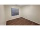 An empty bedroom with wood flooring and a window with blinds provides a simple blank canvas at 3829 W Ashton Dr, Anthem, AZ 85086