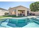 Backyard with swimming pool, outdoor kitchen, covered patio, and artificial grass at 3904 E Carter Dr, Phoenix, AZ 85042