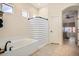 Bright bathroom featuring a tub, shower, and view into the main bedroom at 3904 E Carter Dr, Phoenix, AZ 85042