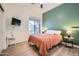 Cozy bedroom with green accent wall, tile floors, and a window with natural light at 3904 E Carter Dr, Phoenix, AZ 85042