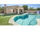 A beautiful pool with an attached hot tub and outdoor kitchen area, surrounded by lush landscaping at 3904 E Carter Dr, Phoenix, AZ 85042