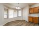 Charming dining area with bay windows and a chandelier, adjacent to the kitchen at 40144 N Lerwick Dr, San Tan Valley, AZ 85140