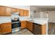 Well-lit kitchen featuring modern stainless steel appliances, wood cabinetry, and sleek countertops at 40144 N Lerwick Dr, San Tan Valley, AZ 85140