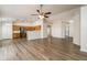 Spacious living room open to the kitchen, featuring wood-look floors and a ceiling fan at 40144 N Lerwick Dr, San Tan Valley, AZ 85140