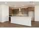 Bright kitchen with white quartz island, tile backsplash, wooden cabinets, stainless hood and appliances at 40250 N Alegre Dr, San Tan Valley, AZ 85140