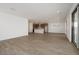 Open-concept living room flowing into kitchen with wood-look tile flooring and bright recessed lighting at 40250 N Alegre Dr, San Tan Valley, AZ 85140