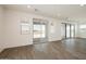 Bright living room with wood-look tile floors, recessed lights, and sliding glass doors to outdoor space at 40250 N Alegre Dr, San Tan Valley, AZ 85140