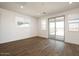 Bright living room with wood-look tile floors, recessed lights, and sliding glass door to patio at 40250 N Alegre Dr, San Tan Valley, AZ 85140
