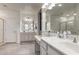 Bright bathroom with double sinks, granite counters, large mirrors and wood-look tile flooring at 4116 E Roy Rogers Rd, Cave Creek, AZ 85331