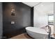 Modern bathroom with sleek soaking tub next to expansive glass window and black tiled shower area at 4422 N 75Th St # 8005, Scottsdale, AZ 85251