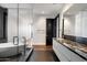 Modern bathroom featuring a soaking tub, frameless shower, black marble counter and sleek white cabinets at 4422 N 75Th St # 8005, Scottsdale, AZ 85251