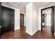 Hallway with dark hardwood floors, contrasting white walls and trim, and black doors at 4422 N 75Th St # 8005, Scottsdale, AZ 85251