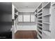 Spacious walk-in closet with custom built-in shelving and dark wood floor at 4422 N 75Th St # 8005, Scottsdale, AZ 85251