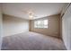 Minimalist bedroom featuring neutral walls and carpet, a ceiling fan, and a bright window at 4523 W Bluefield Ave, Glendale, AZ 85308