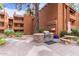 Outdoor BBQ area with a grill, stone counter, seating, and mature trees at 4704 E Paradise Village Pkwy # 213, Phoenix, AZ 85032