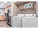 Convenient laundry room with stainless steel refrigerator, washer, dryer, and shelving at 4704 E Paradise Village Pkwy # 213, Phoenix, AZ 85032