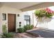 Inviting covered front entry with mature landscaping, brick accents, and a solid wood front door at 5101 N Casa Blanca Dr # 217, Paradise Valley, AZ 85253