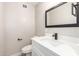 Modern bathroom with a white vanity, black fixtures, and neutral walls at 5208 W Earll Dr, Phoenix, AZ 85031