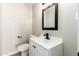 Stylish powder room featuring a white vanity, black hardware, and brick wall at 5208 W Earll Dr, Phoenix, AZ 85031