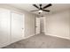 This bedroom features a ceiling fan, neutral paint, a closet, and gray carpet at 5208 W Earll Dr, Phoenix, AZ 85031