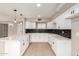 Bright kitchen with black subway tile, quartz countertops, and white cabinetry at 5208 W Earll Dr, Phoenix, AZ 85031