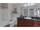 Well-lit bathroom with a black countertop, dark wood cabinets, framed art, and a shower-tub combo at 5335 E Shea Blvd # 2022, Scottsdale, AZ 85254