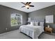 Cozy bedroom featuring a ceiling fan, a queen bed with soft, white bedding, and natural light from the arched window at 5335 E Shea Blvd # 2022, Scottsdale, AZ 85254