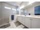 Modern bathroom featuring a double sink, white cabinets, and a glass shower with tiled walls at 5621 N 189Th Dr, Litchfield Park, AZ 85340