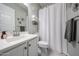 This bathroom features a white shower curtain, grey walls, and white cabinets at 5621 N 189Th Dr, Litchfield Park, AZ 85340