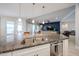 The kitchen island features granite countertops, a stainless sink, and barstool seating with a view of the living room at 5621 N 189Th Dr, Litchfield Park, AZ 85340