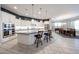 Open-concept kitchen with an island and white cabinetry, stainless steel appliances, and pendant lighting at 5621 N 189Th Dr, Litchfield Park, AZ 85340