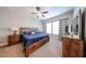 The main bedroom with a wooden bed frame, ceiling fan, ensuite bathroom and dresser offers storage space at 5621 N 189Th Dr, Litchfield Park, AZ 85340