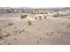 Aerial view of the beige desert home with white trim and desert landscaping at 6431 N 418Th Ave, Tonopah, AZ 85354