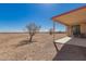 Covered patio featuring desert landscaping, neutral stucco with red trim, and mountain views at 6431 N 418Th Ave, Tonopah, AZ 85354