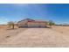 Home featuring a three-car garage, desert landscape, and neutral stucco with red trim at 6431 N 418Th Ave, Tonopah, AZ 85354