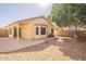 Back of the home with patio, privacy wall, and a mature shade tree at 6718 E Northridge St, Mesa, AZ 85215