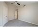 A spacious bedroom has a ceiling fan and light-colored walls, door, and carpeting at 6718 E Northridge St, Mesa, AZ 85215